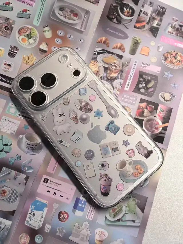 Smartphone with decorative case featuring cute stickers on collage background with pastel theme