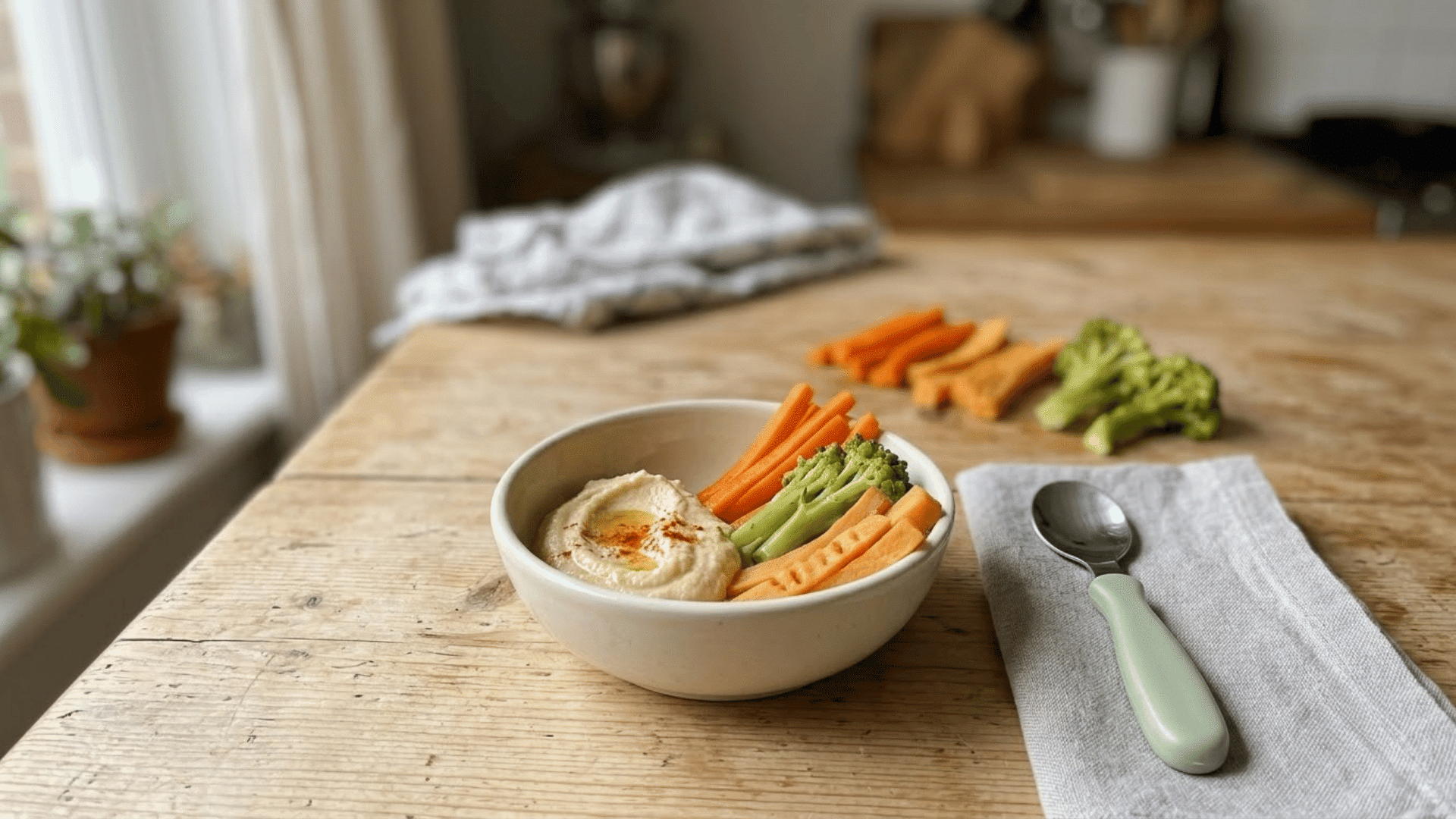 hummus served with soft-cooked carrot, broccoli, and sweet potato strips