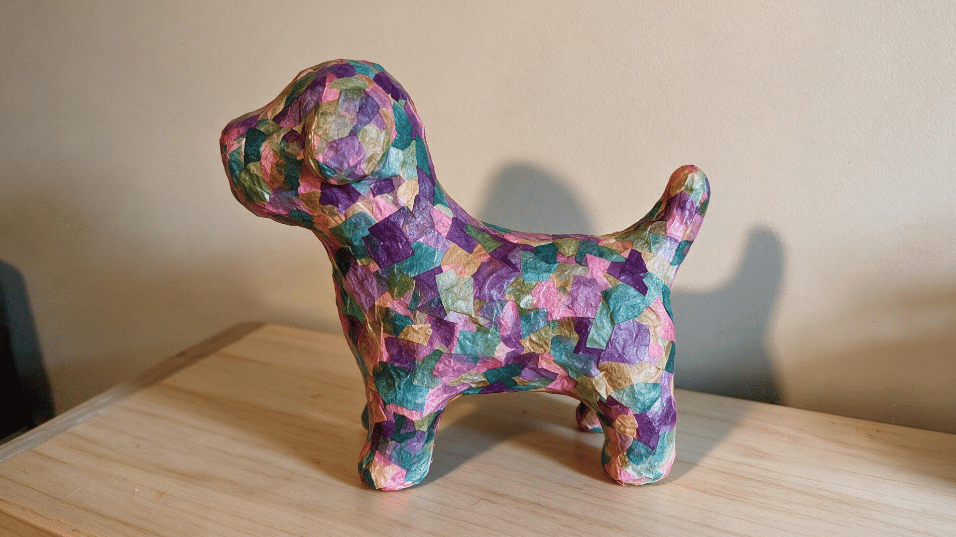 paper mache animal sculpture with colorful tissue paper pieces on a wooden table