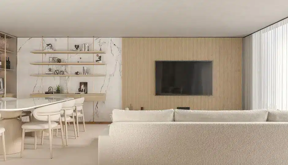 Modern living room with beige sofa, marble wall, shelves, and wall-mounted TV in soft natural light
