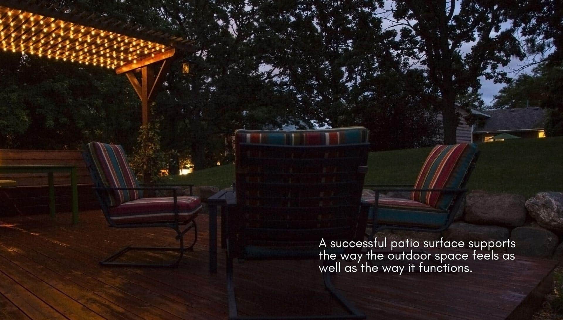 Outdoor patio at night with string lights and striped cushioned chairs on wooden deck