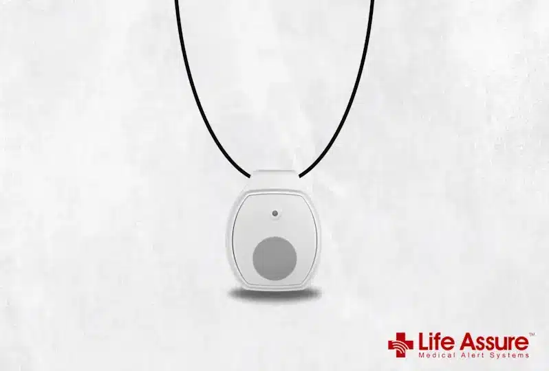White medical alert pendant with black cord on a light gray textured background